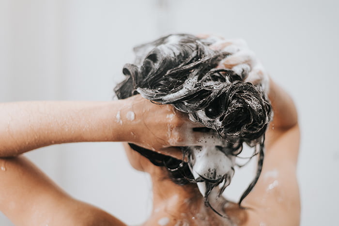 woman washing hair with shampoo